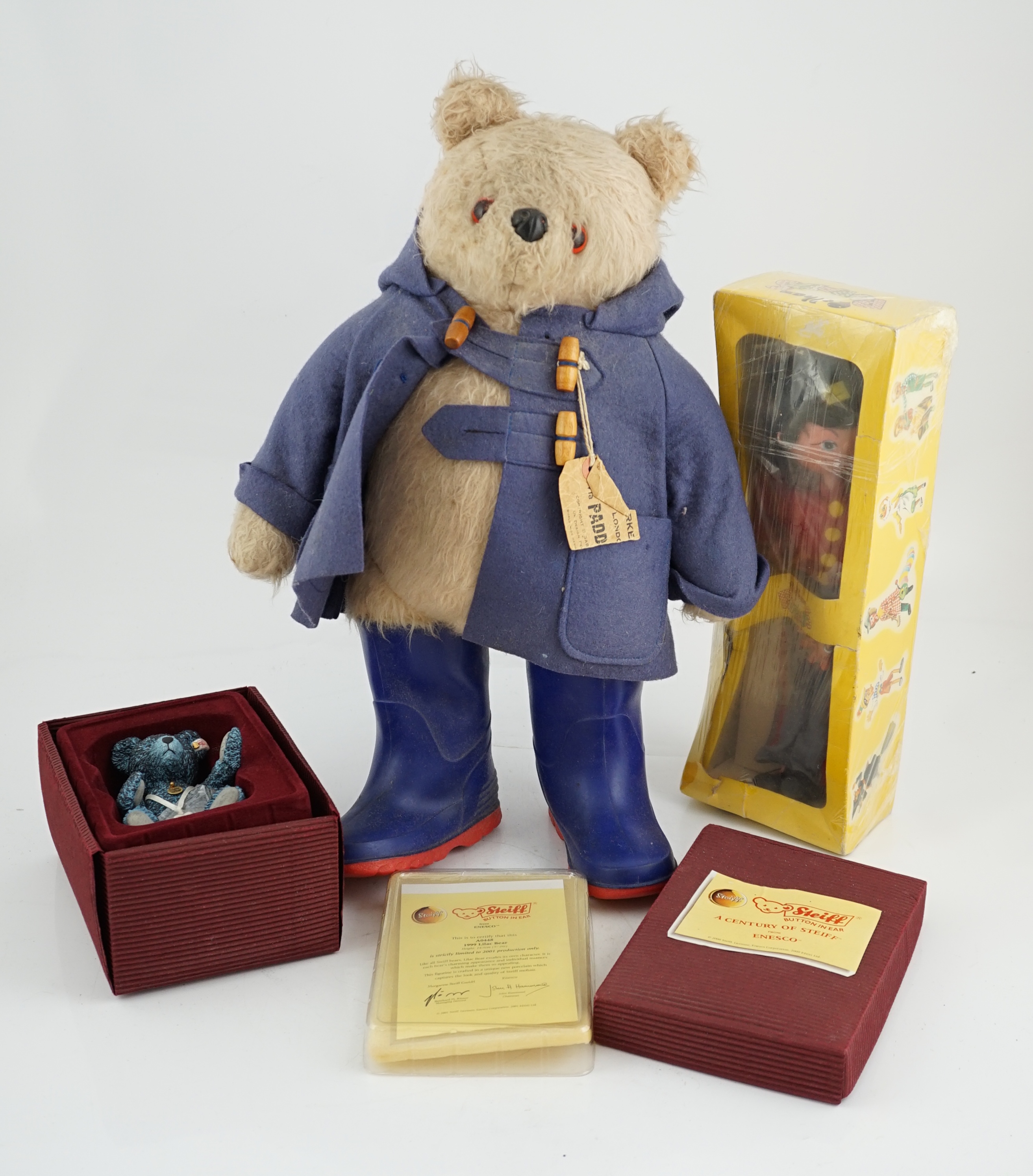 An early Paddington bear, blue jacket, missing hat, a Steiff Ltd. edition lilac bear in box, and a porcelain Pelham puppet in box, good condition